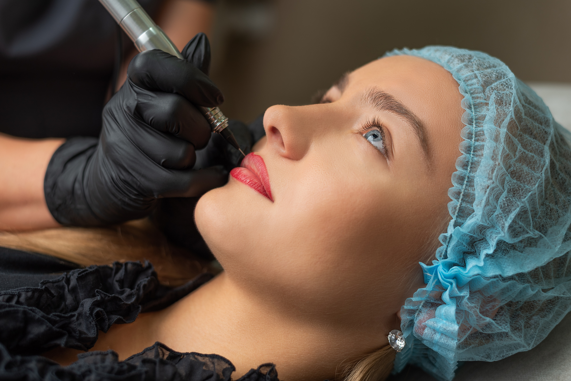 A young girl having lips permanent makeup, micropigmentation.